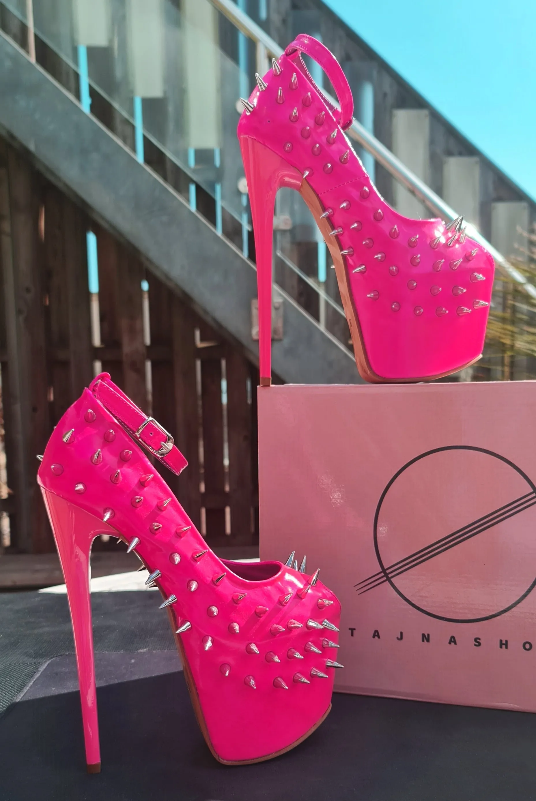 Glossy hot neon pink ankle strap heels with spike studs.