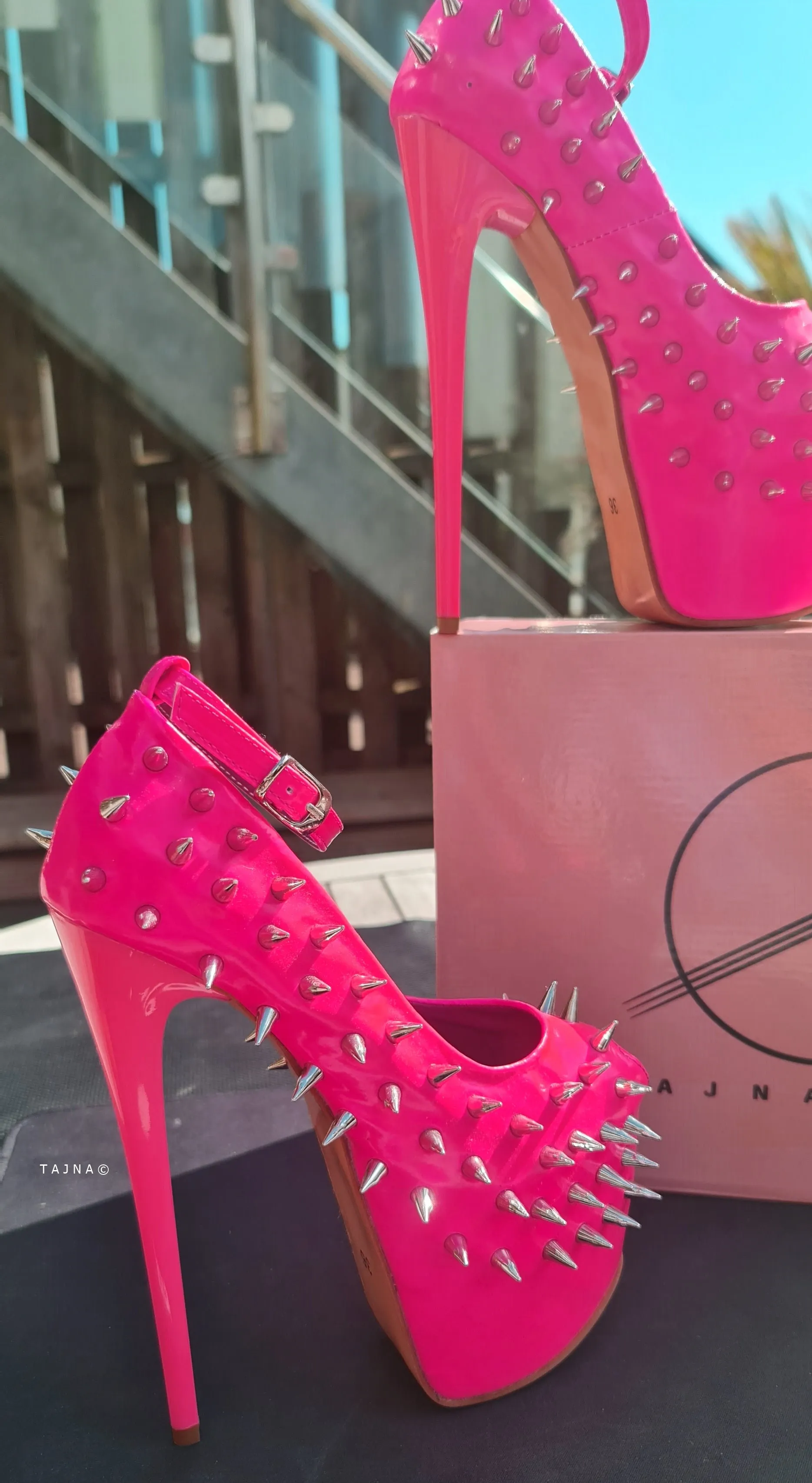 Glossy hot neon pink ankle strap heels with spike studs.