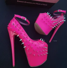 Glossy hot neon pink ankle strap heels with spike studs.