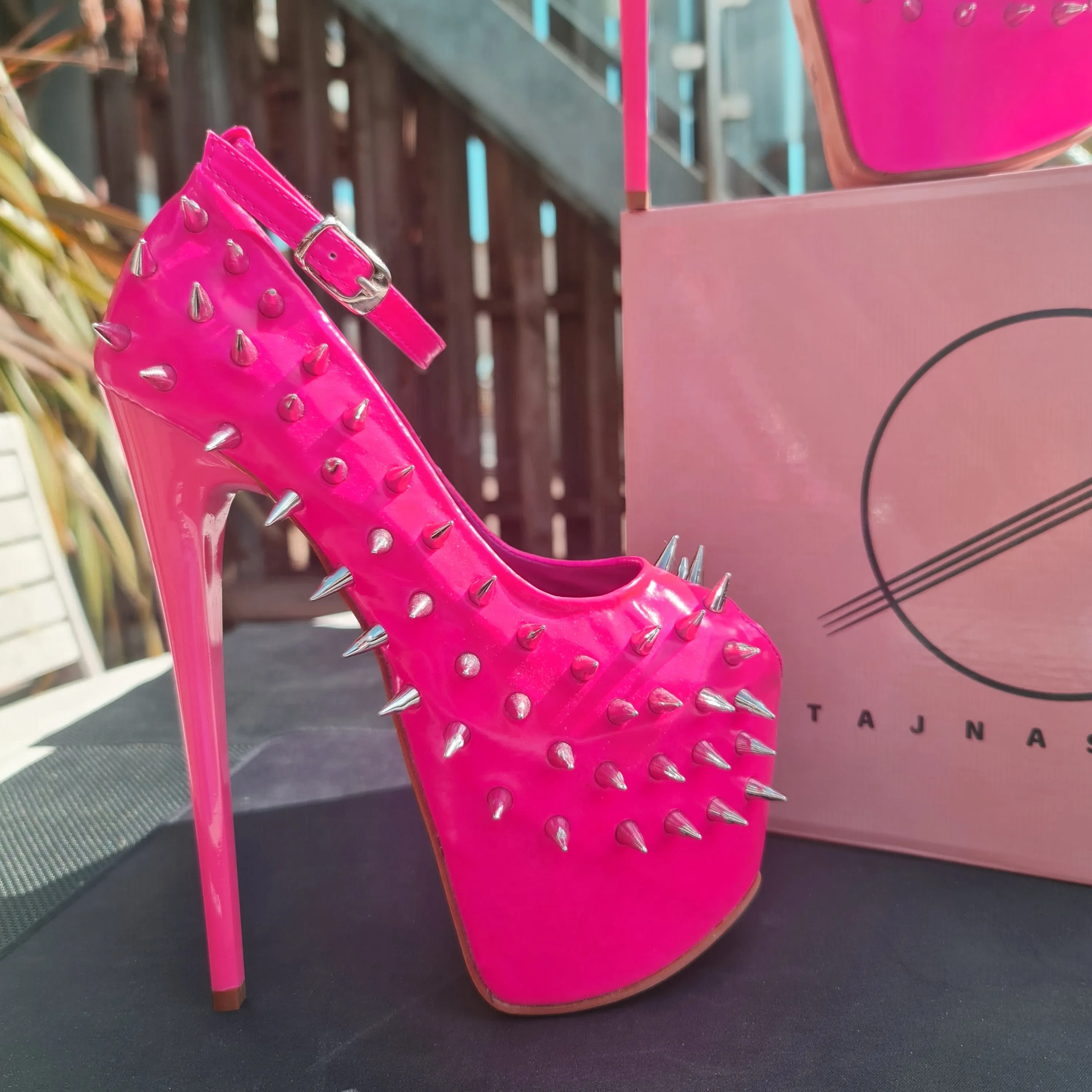 Glossy hot neon pink ankle strap heels with spike studs.