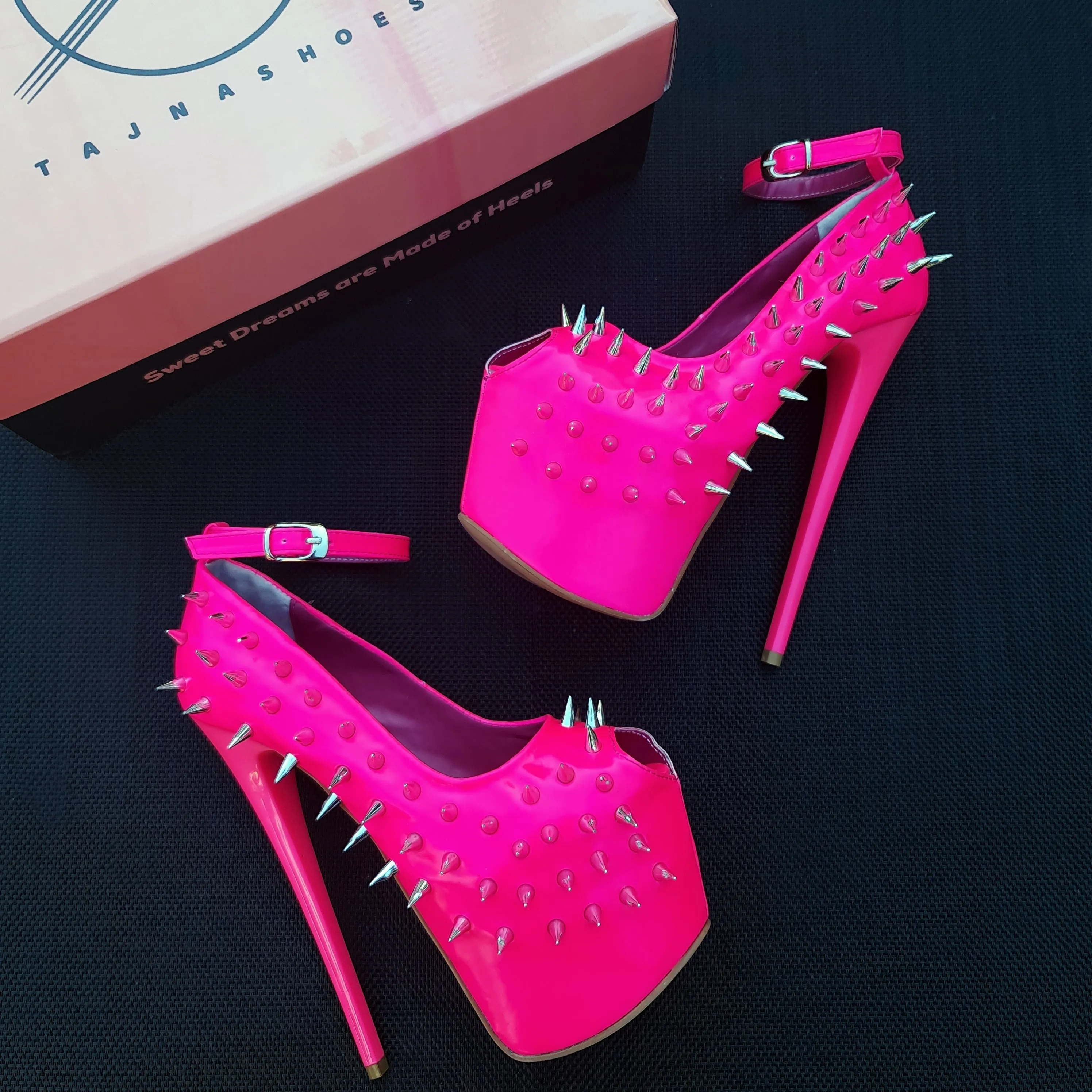 Glossy hot neon pink ankle strap heels with spike studs.