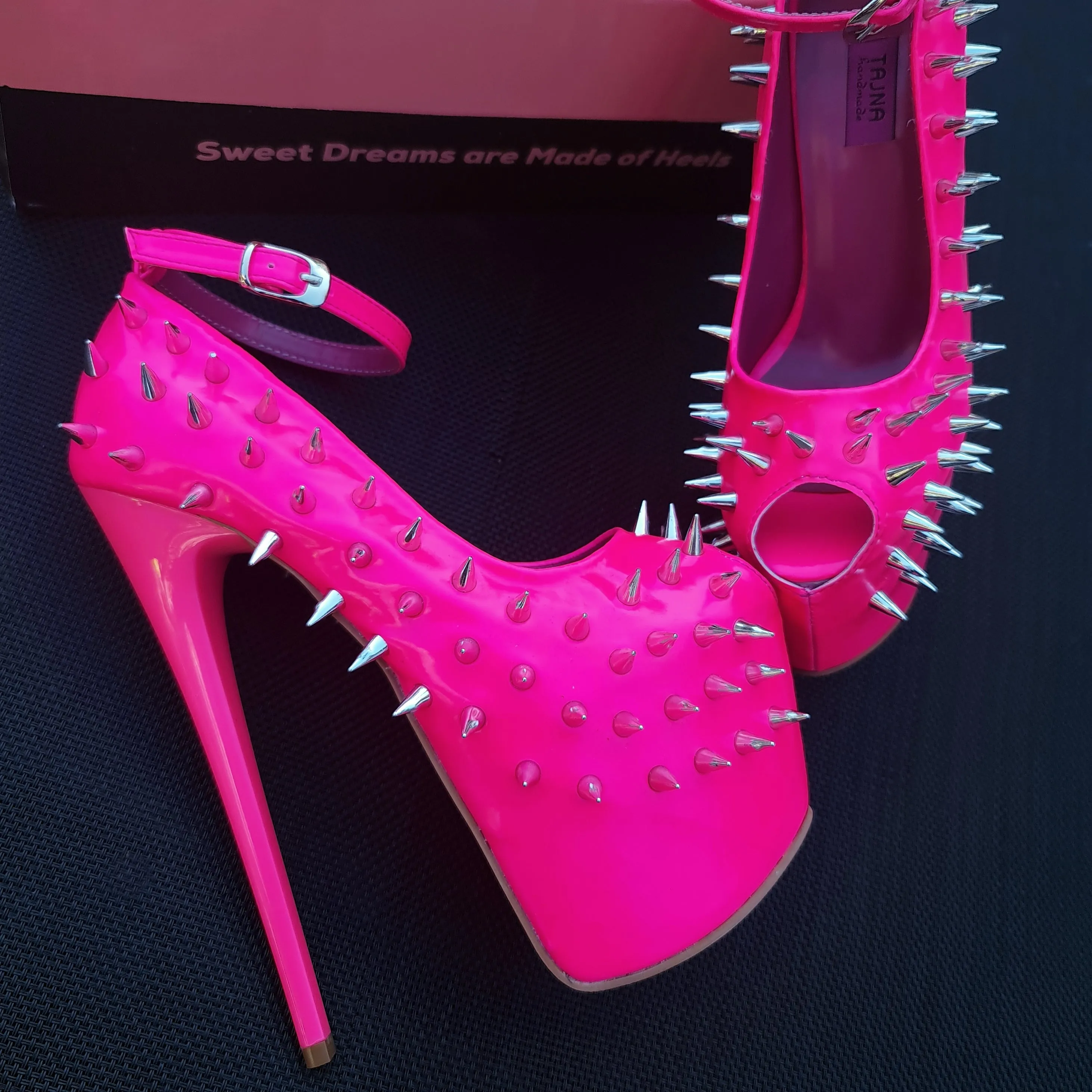 Glossy hot neon pink ankle strap heels with spike studs.