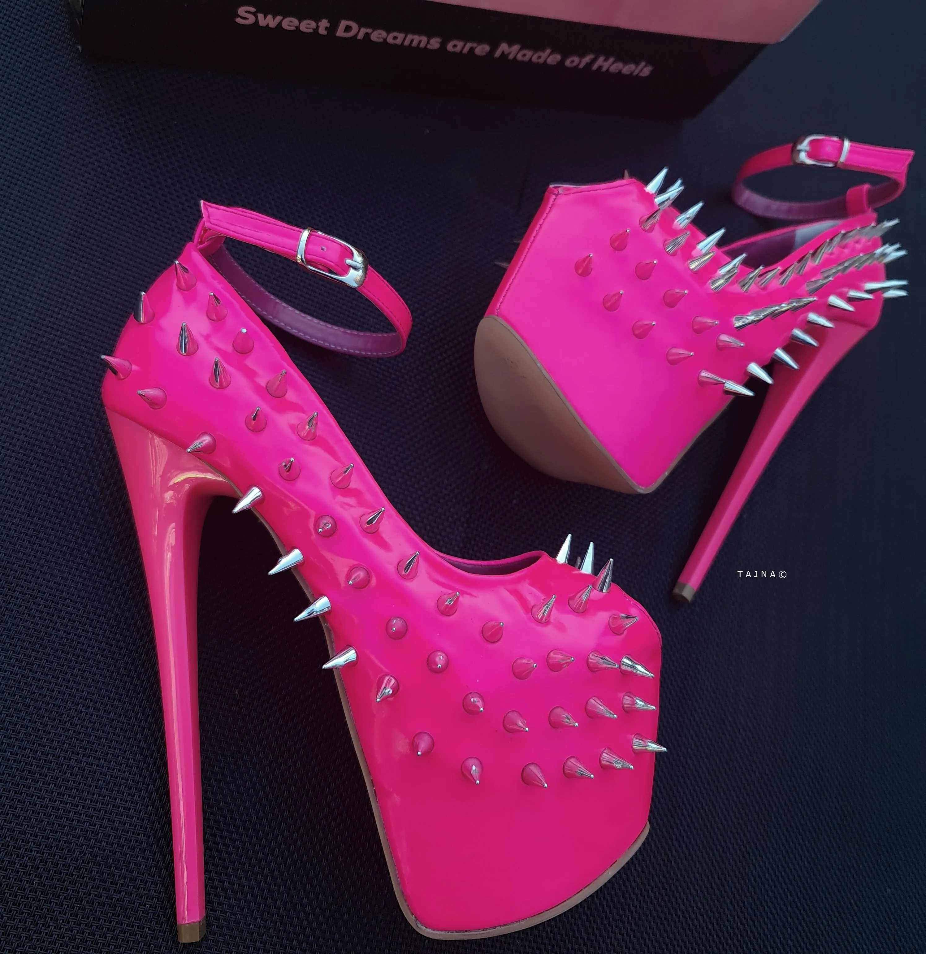 Glossy hot neon pink ankle strap heels with spike studs.