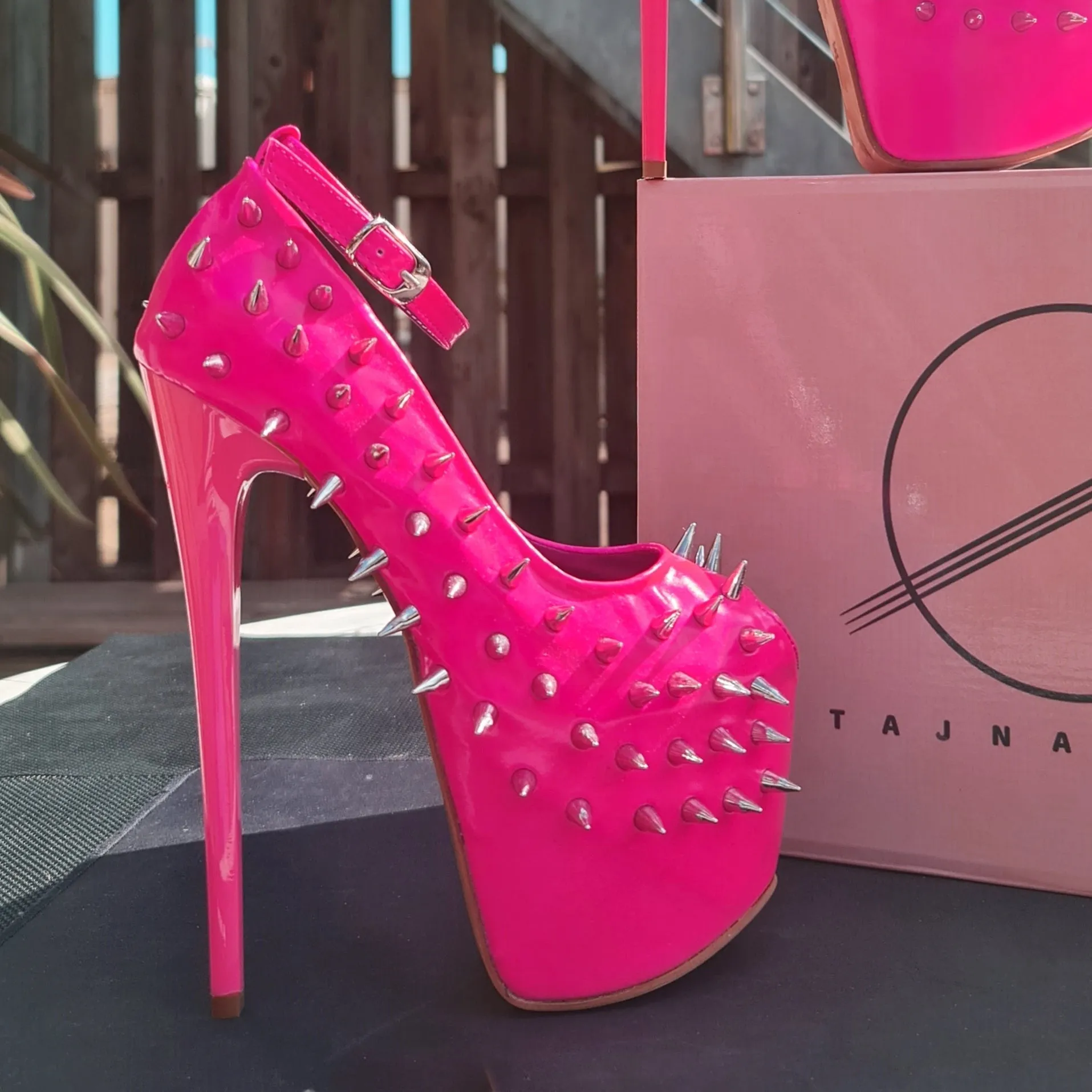 Glossy hot neon pink ankle strap heels with spike studs.